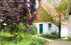 a white house with a green door and trees at Stunning Home In Morschen With Kitchen in Morschen