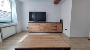 a living room with a television on a wooden dresser at Stare Miasto in Kłodzko