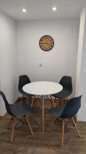 a table with four chairs and a clock on a wall at Stare Miasto in Kłodzko