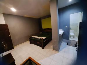 Banyuwangi Baru Homestay في بانيووانجى: حمام به سرير ومرحاض ومغسلة