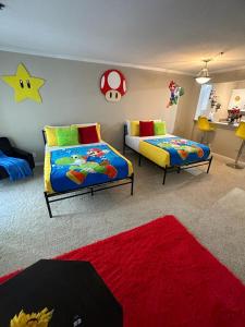 a bedroom with two beds and a red rug at Súper Mario Universal Studios 10 min Loft Free parking in Los Angeles