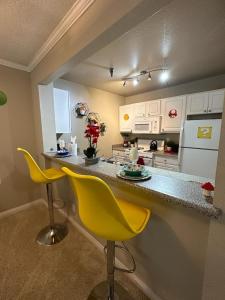 a kitchen with a counter and two yellow chairs at Súper Mario Universal Studios 10 min Loft Free parking in Los Angeles