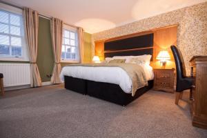 um quarto com uma cama grande e 2 janelas em 34 Argyle Guesthouse em St Andrews