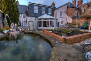 einen Garten mit einem Teich vor einem Haus in der Unterkunft 34 Argyle Guesthouse in St Andrews