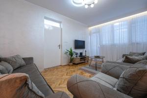 ein Wohnzimmer mit einem Sofa und einem TV in der Unterkunft Clock Tower Lux Apartment in Podgorica