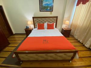 um quarto com uma cama grande e lençóis vermelhos em HOTEL VELANEZ SUITE Riobamba em Riobamba