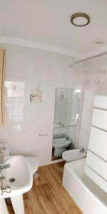 La salle de bains blanche est pourvue d'un lavabo et de toilettes. dans l'établissement Casa Vistas a Trafalgar sólo familias o parejas - Parking privado opcional -, à Conil de la Frontera