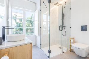 een badkamer met een douche, een wastafel en een toilet bij LODO Suits Ala - Studio mezanino by HD in Faro