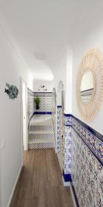 un couloir avec des carreaux bleus et blancs et un miroir dans l'établissement Casa Vistas a Trafalgar sólo familias o parejas - Parking privado opcional -, à Conil de la Frontera