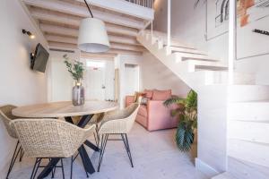 a dining room with a table and chairs and a staircase at LODO Suits Se - Mezanino room by HD in Faro