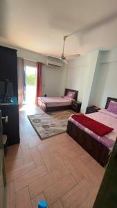 een woonkamer met 2 bedden en een televisie bij Cheerful villa with pool in Alexandria (El agami) in Alexandrië