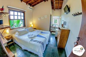 a bedroom with a bed and a desk and a sink at Pousada Manga Rosa in Ilhabela +58 photos