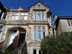 a large stone house with an archway in front of it at OYO No 3 in Bath