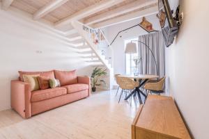 a living room with a couch and a table at LODO Suits Se - Mezanino room by HD in Faro