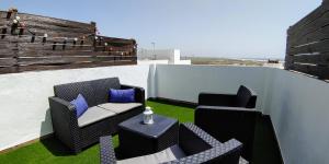 eine Dachterrasse mit 2 Stühlen und einem Tisch in der Unterkunft Casa Vistas a Trafalgar sólo familias o parejas - Parking privado opcional - in Conil de la Frontera