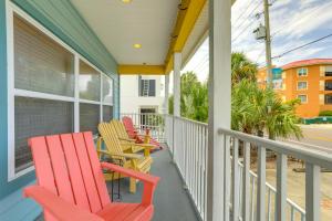 a row of colorful chairs on the porch of a house at Vibrant Condo - Walk to Indian Rocks Beach! in Clearwater Beach