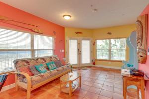 a living room with a couch and some windows at Vibrant Condo - Walk to Indian Rocks Beach! in Clearwater Beach