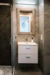 La salle de bains est pourvue d'un lavabo et d'un miroir. dans l'établissement Apartamenty DIAGO, à Łeba