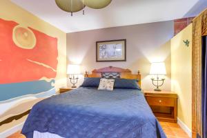 a bedroom with a blue bed and two lamps at Vibrant Condo - Walk to Indian Rocks Beach! in Clearwater Beach