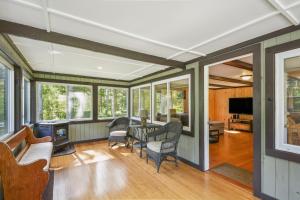 Brantingham Cabin with Porch and Grill On 5 Acres! في Glenfield: غرفة معيشة مفتوحة مع طاولة وكراسي