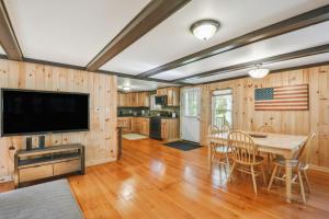 a kitchen and dining room with a table and a television at Brantingham Cabin with Porch and Grill On 5 Acres! in Glenfield