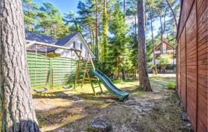 um parque infantil com escorrega em frente a uma casa em Awesome Home In Pogorzelica With Kitchen em Pogorzelica