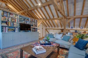 a living room with a couch and a tv at Manor Farm Barn in Oundle