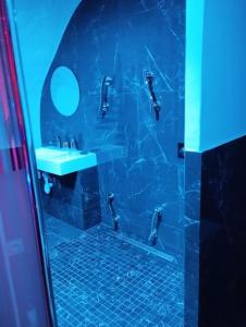 a blue bathroom with a sink and a mirror at La suite Miroir, Love Room in Bouc-Bel-Air