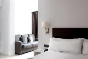 バルセロナにあるカタロニア アルベニスのベッドとソファ付きのホテルルーム