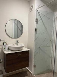 a bathroom with a sink and a glass shower at Luxury Cantonments Suite in Accra