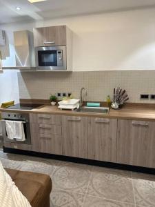 a kitchen with a sink and a microwave at Luxury Cantonments Suite in Accra