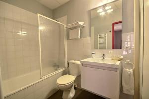 a bathroom with a toilet and a sink and a shower at Hotel Central in Saint-Pierre-dʼAlbigny