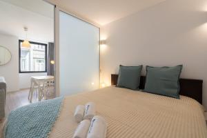 Un dormitorio con una cama con dos pares de zapatos. en Host Wise - Charming Welcoming Flat - Centrally Located, en Oporto