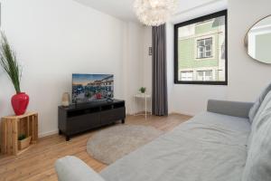 a living room with a couch and a tv at Charming Welcoming Flat - Centrally Located in Porto