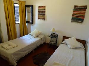 una habitación con dos camas y una ventana en Hostel, LA LULA, en Vinchina
