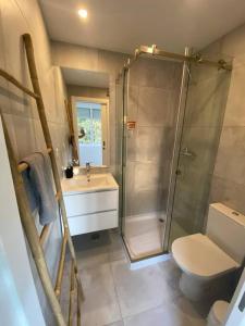 uma casa de banho com um chuveiro, um WC e um lavatório. em Carcavelos Beach Five Guests apartment em Oeiras