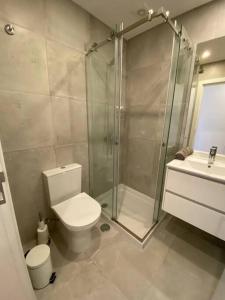 uma casa de banho com um chuveiro, um WC e um lavatório. em Carcavelos Beach Five Guests apartment em Oeiras