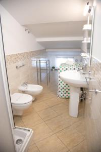 a bathroom with two sinks and a toilet and a bed at Happy Home in Giardini Naxos