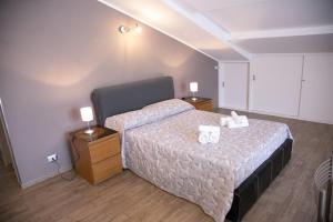 una camera da letto con un letto con due asciugamani bianchi di Happy Home a Giardini Naxos