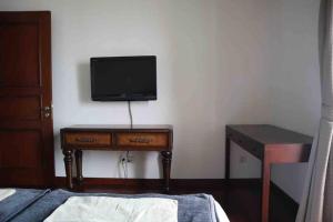 1 dormitorio con escritorio y TV en la pared en 2BR The Belleza at Permata Hijau 18th Floor en Yakarta