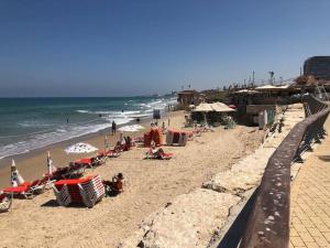 - une plage avec des chaises et des parasols dans l'établissement Luxury sea view apartment, à Tel Aviv