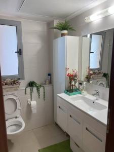 La salle de bains blanche est pourvue de toilettes et d'un lavabo. dans l'établissement Luxury sea view apartment, à Tel Aviv