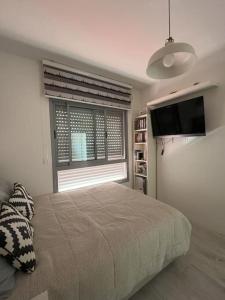 - une chambre avec un lit et une fenêtre avec une télévision à écran plat dans l'établissement Luxury sea view apartment, à Tel Aviv