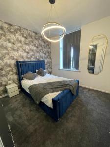 a bedroom with a blue bed and a mirror at Lumiere luxury apartment 