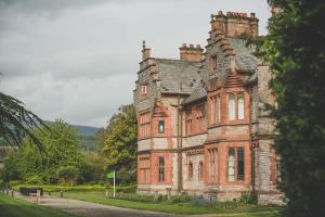 an old red brick building with a tower at Caer Rhun Hall Hotel in Conwy