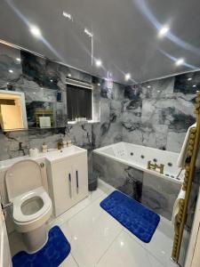 a bathroom with a toilet and a tub and a sink at Lumiere luxury apartment 