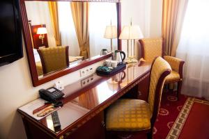a hotel room with a desk and a mirror at Hotel Holiday Park in Warsaw