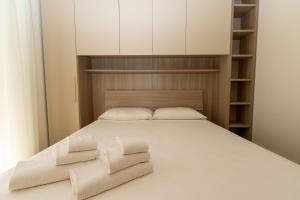 1 dormitorio con 1 cama blanca y 2 almohadas en DimmiDiRimini - Appartamenti in Affitto en Rímini