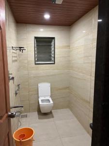 a bathroom with a toilet and a window at Hotel Jeet Paradise in Phaltan