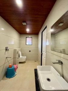 a bathroom with a sink and a toilet at Hotel Jeet Paradise in Phaltan